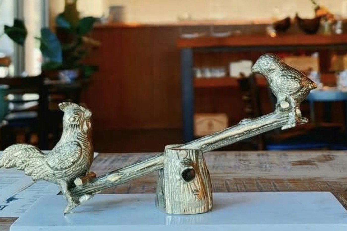 Gold bird sculpture on a dining table inside The Roost